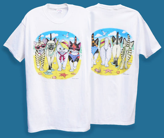 a t-shirts featuring a graphic print of cartoon cats in summer attire on a beach-themed background.