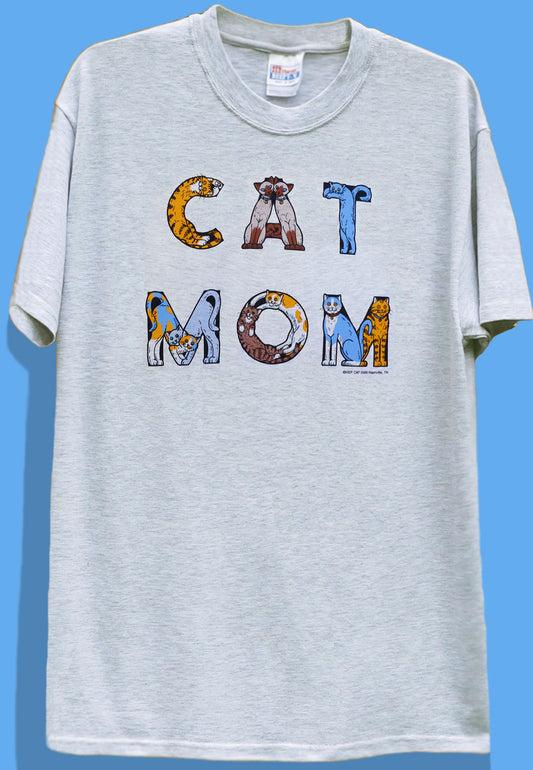 White crew neck t-shirt with the text 'CAT MOM' printed in bold letters, featuring a graphic of a cat in each letter.