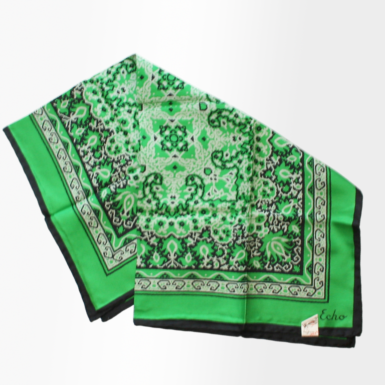 A vibrant green silk scarf with a geometric bandana print and a hand-rolled hem, signed with the brand Echo.