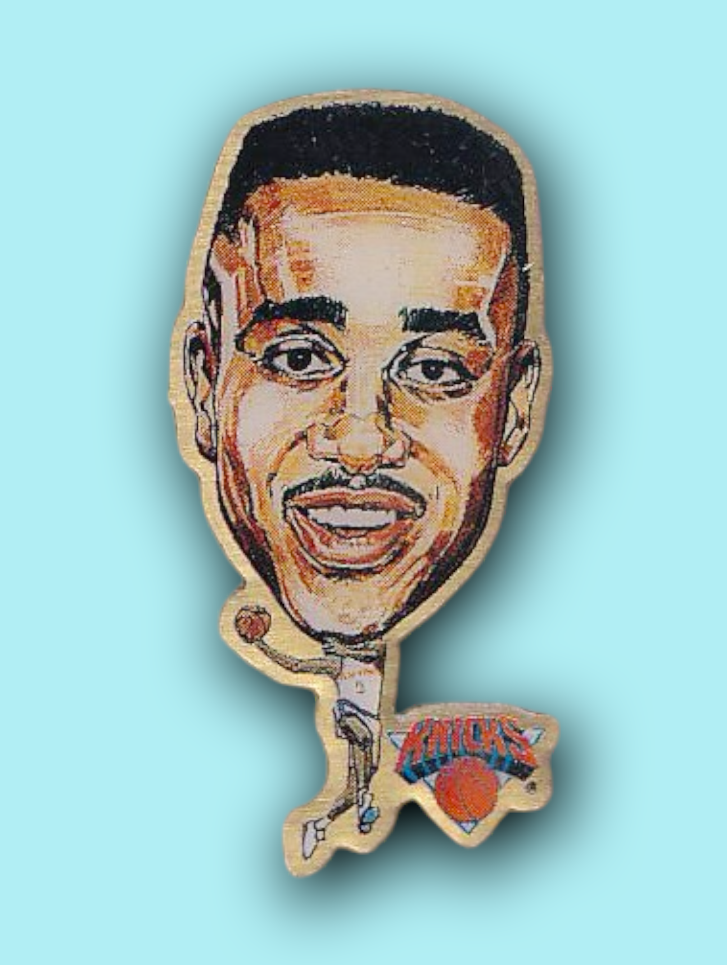 An enamel pin featuring a portrait of John Starks