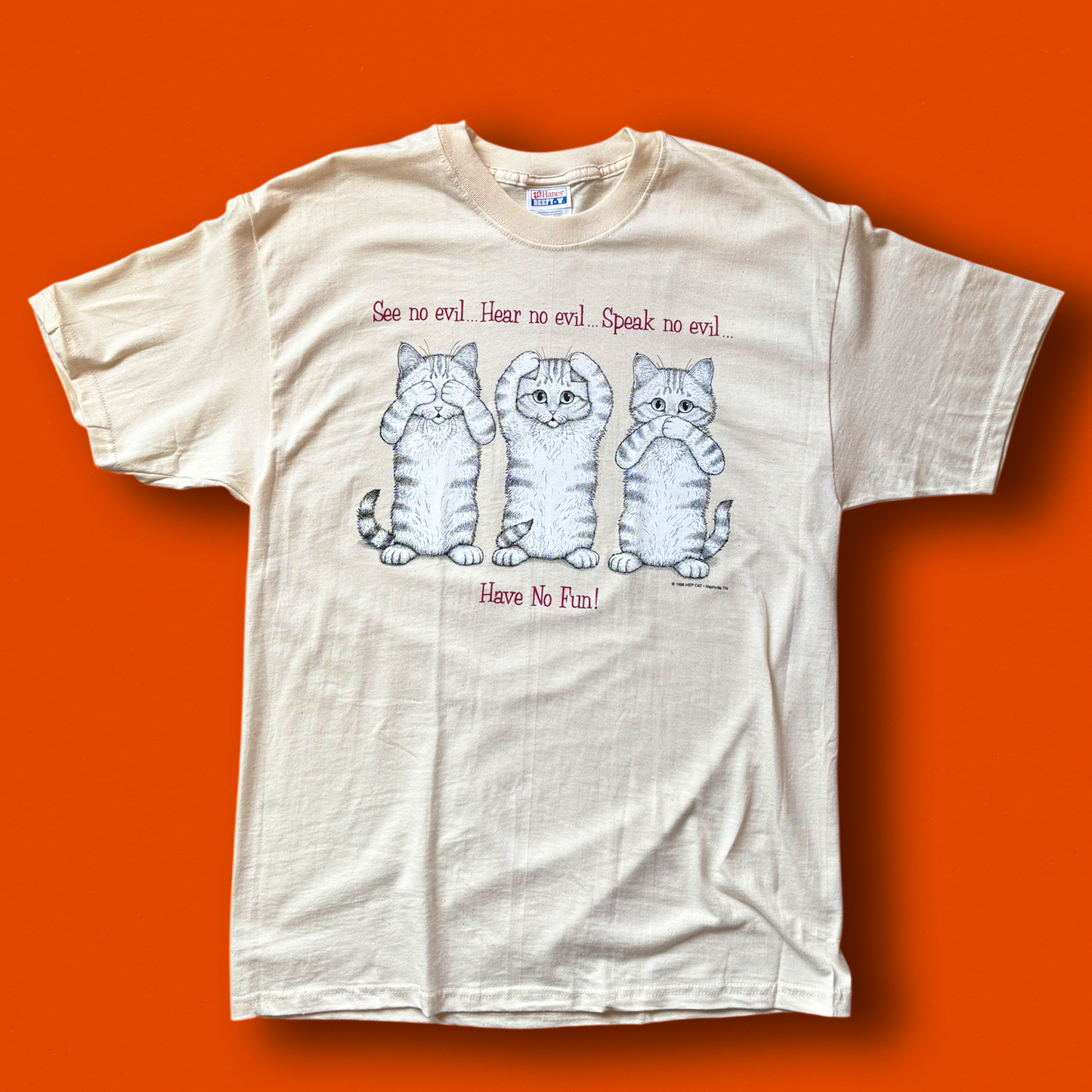 A off-white t-shirt with a graphic print of three cats and the text 'See no evil, Hear no evil, Speak no evil, Have No Fun!'