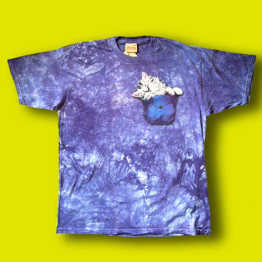 A tie-dye t-shirt with a graphic of a kitten in a pocket on the front.