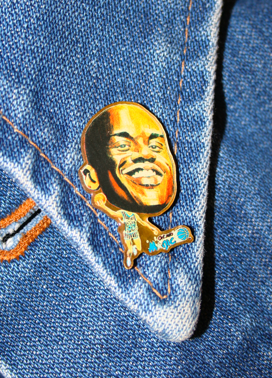 An enamel pin featuring a portrait of a Shaq