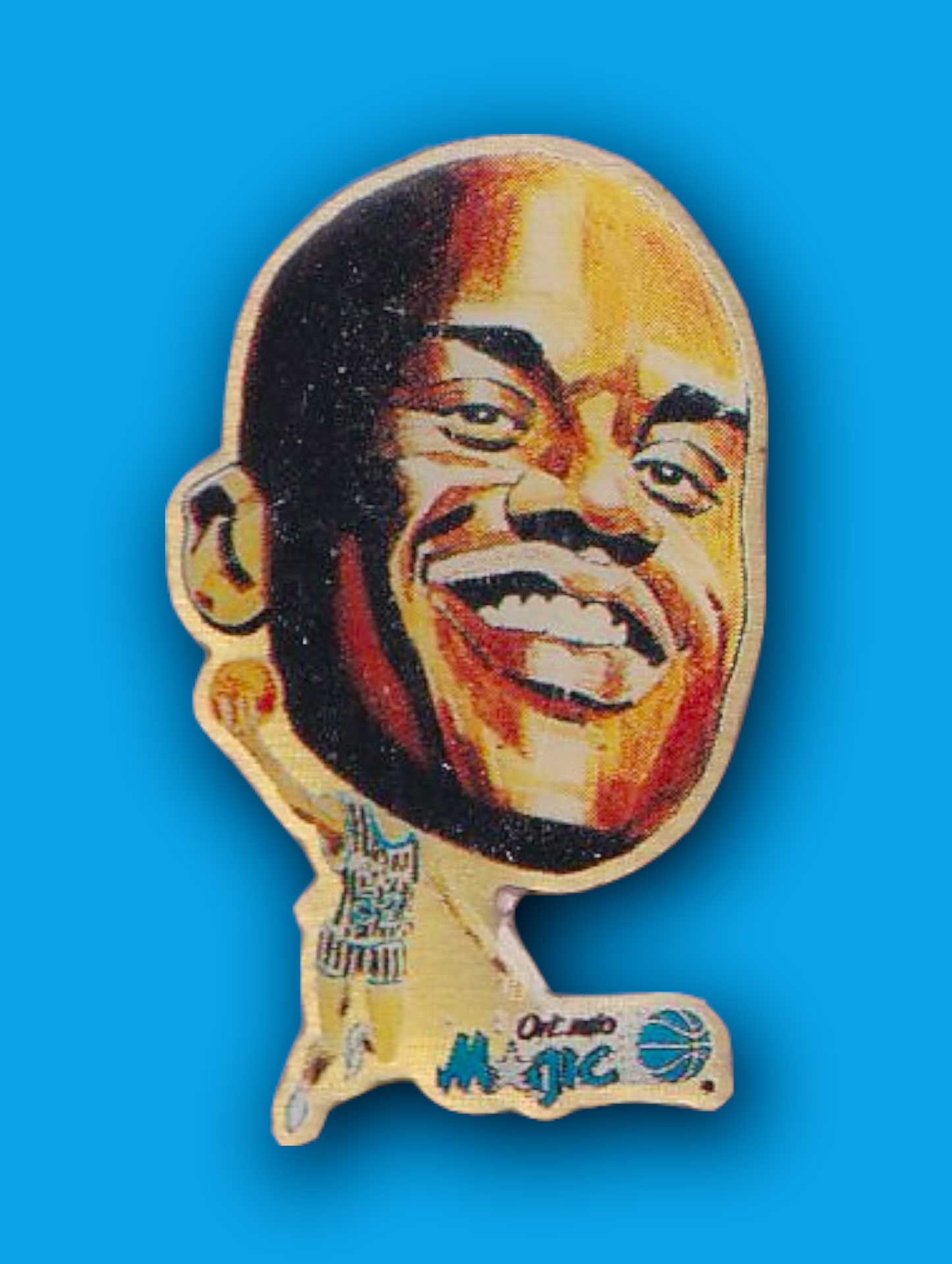 An enamel pin featuring a portrait of Shaq