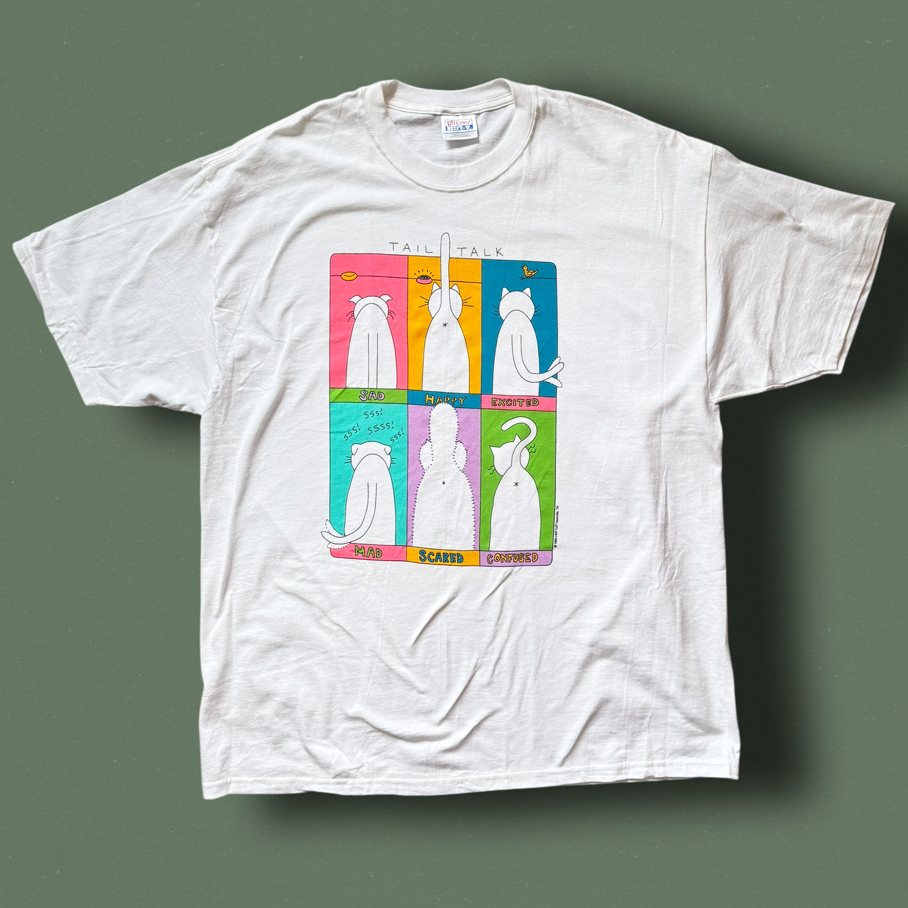 A white crew neck t-shirt with a graphic print of a cat in different poses on a multicolored background. Hep Cat Vintage Tee.