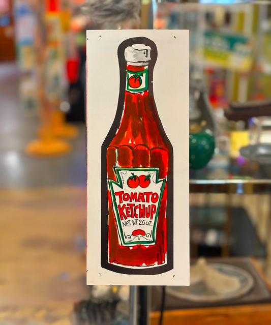 A vibrant red and green art print of a tomato ketchup bottle with a 'Tomato Ketchup' text and cherry design, displayed against a blurred background.