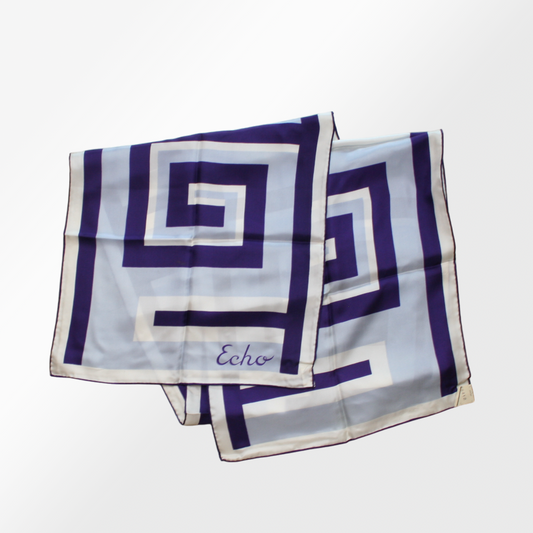 A silk scarf with a Greek key pattern in blue and white, signed with the brand name Echo.