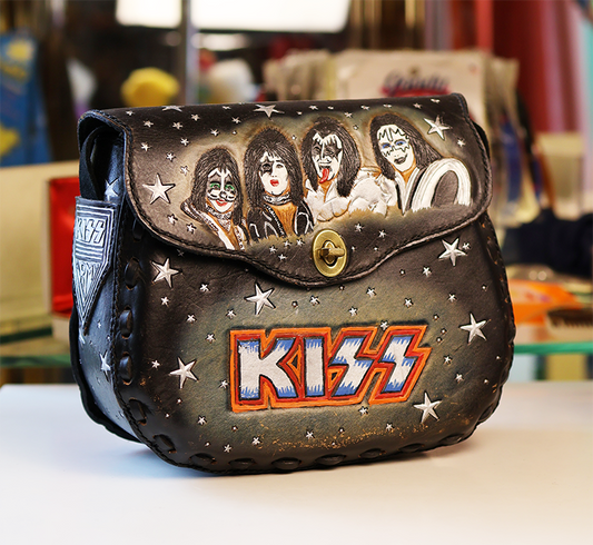 Kiss-themed handbag with band members and logo on a blurred background