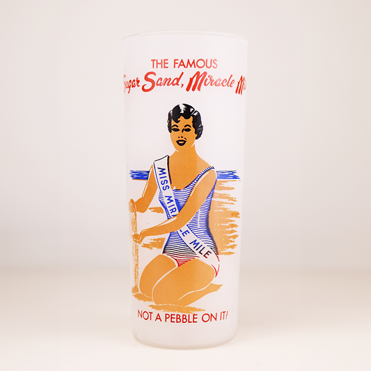 Vintage glassware with a woman in a swimsuit and text on a white background