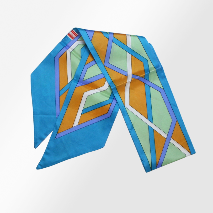 A silk scarf with a geometric pattern in multiple colors, including blue, orange, and green.