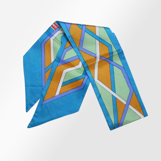 A silk scarf with a geometric pattern in multiple colors, including blue, orange, and green.
