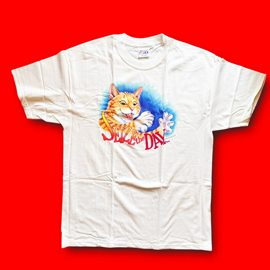 A white crew neck t-shirt with a colorful graphic print of a cat and the text 'Seize the Day!' on a red background.