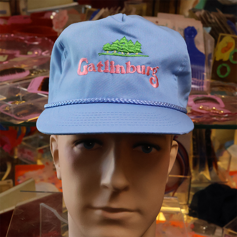 Blue cap with 'Gatlinburg' embroidery on a mannequin head in a store setting
