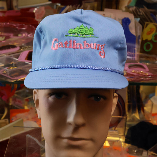 Blue cap with 'Gatlinburg' embroidery on a mannequin head in a store setting