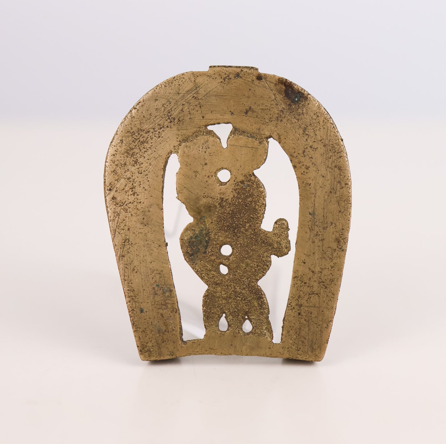 Bronze horseshoe with a cut-out figure on a white background
