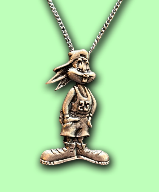 A silver-tone pendant of Bugs Bunny wearing a basketball jersey and shorts with a chain necklace.