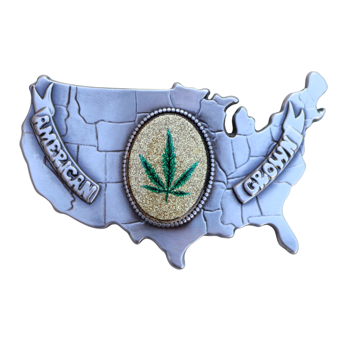 vintage belt buckle of the usa with a marijuana leaf emblem in the middle reading 'american grown'