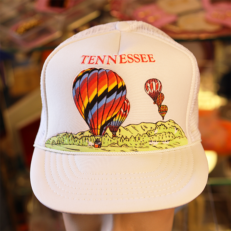 White cap with hot air balloon design and 'TENNESSEE' text in a store setting