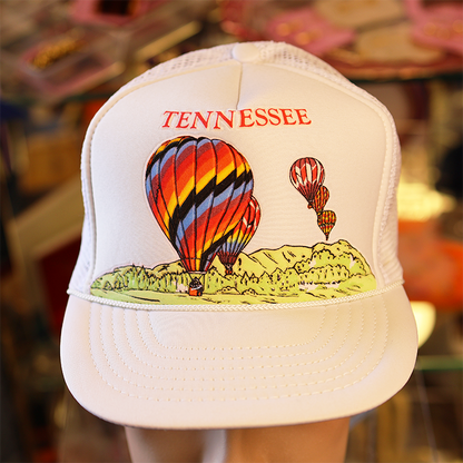 White cap with hot air balloon design and 'TENNESSEE' text in a store setting