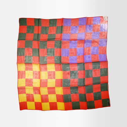 A multicolored sheer scarf with a checkered pattern laid out flat.
