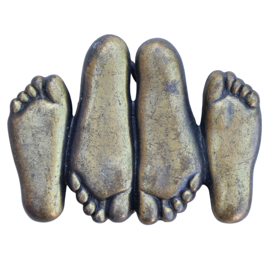 vintage belt buckle of feet in a suggestive position