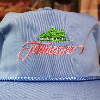 Blue cap with embroidered 'Tennessee' and landscape design on a blurred background