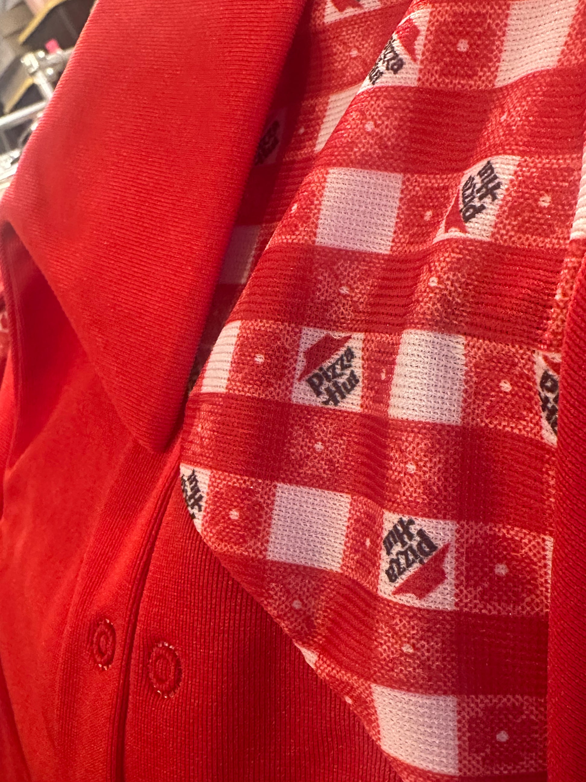Close up of Vintage Pizza Hut Red Uniform shirt top. New Old Stock Deadstock with Pizza Hut signature table cloth print on yoke
