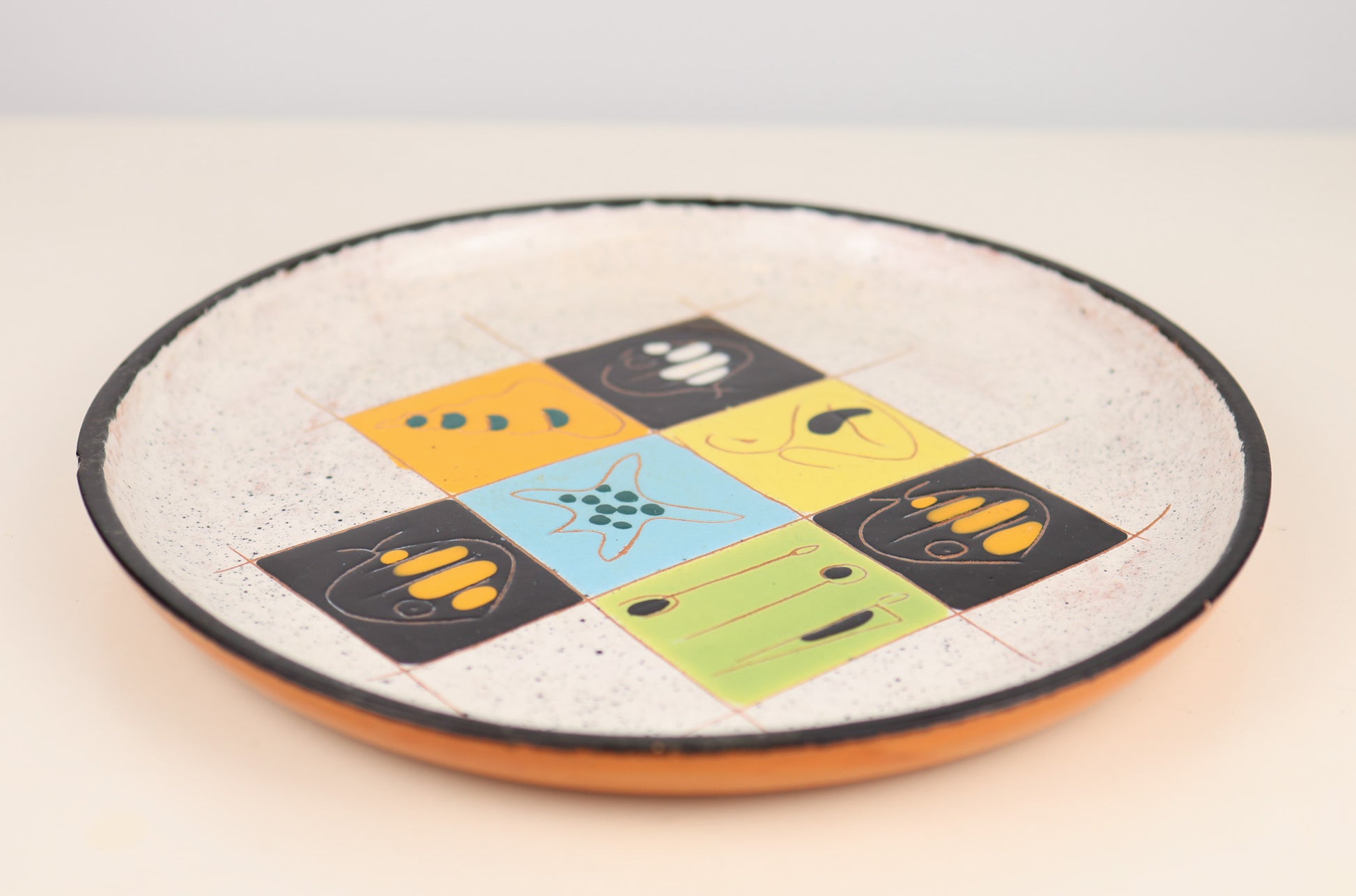 Vintage pottery Round ceramic plate with colorful geometric design on a light background Rosi Italy