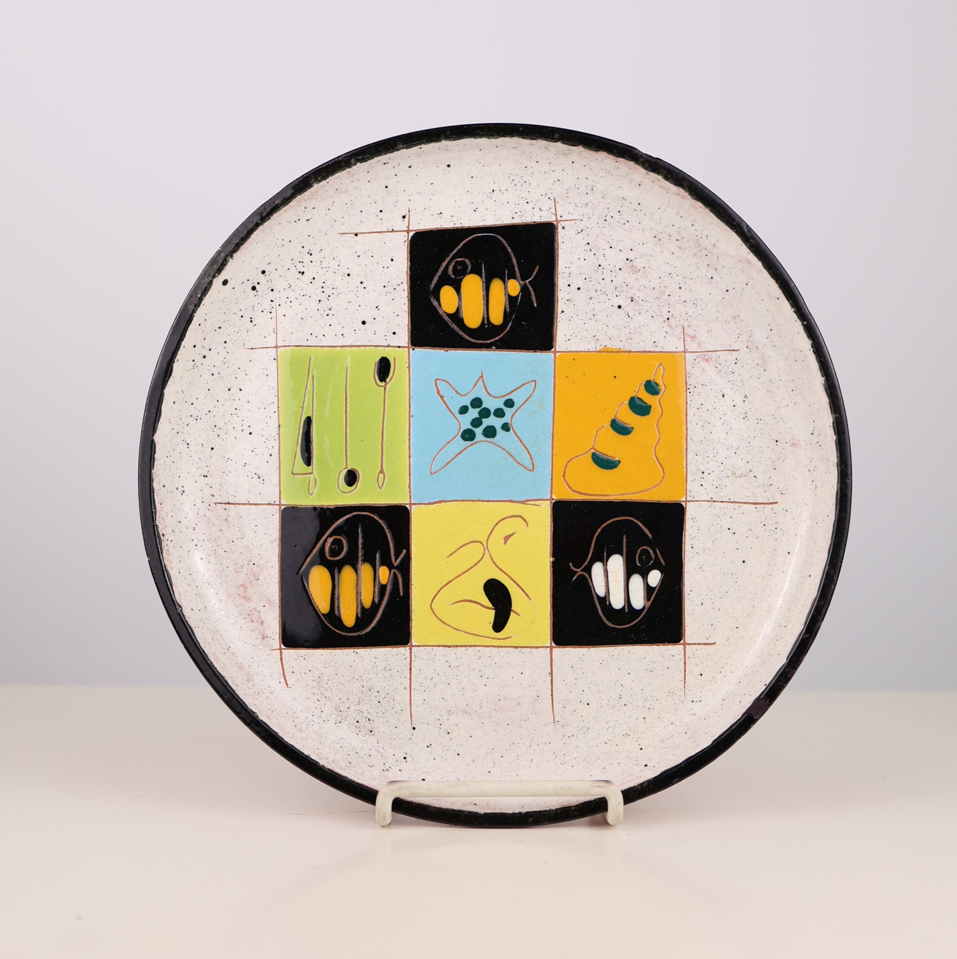 Vintage mid-century Ceramic plate with abstract designs on a white background