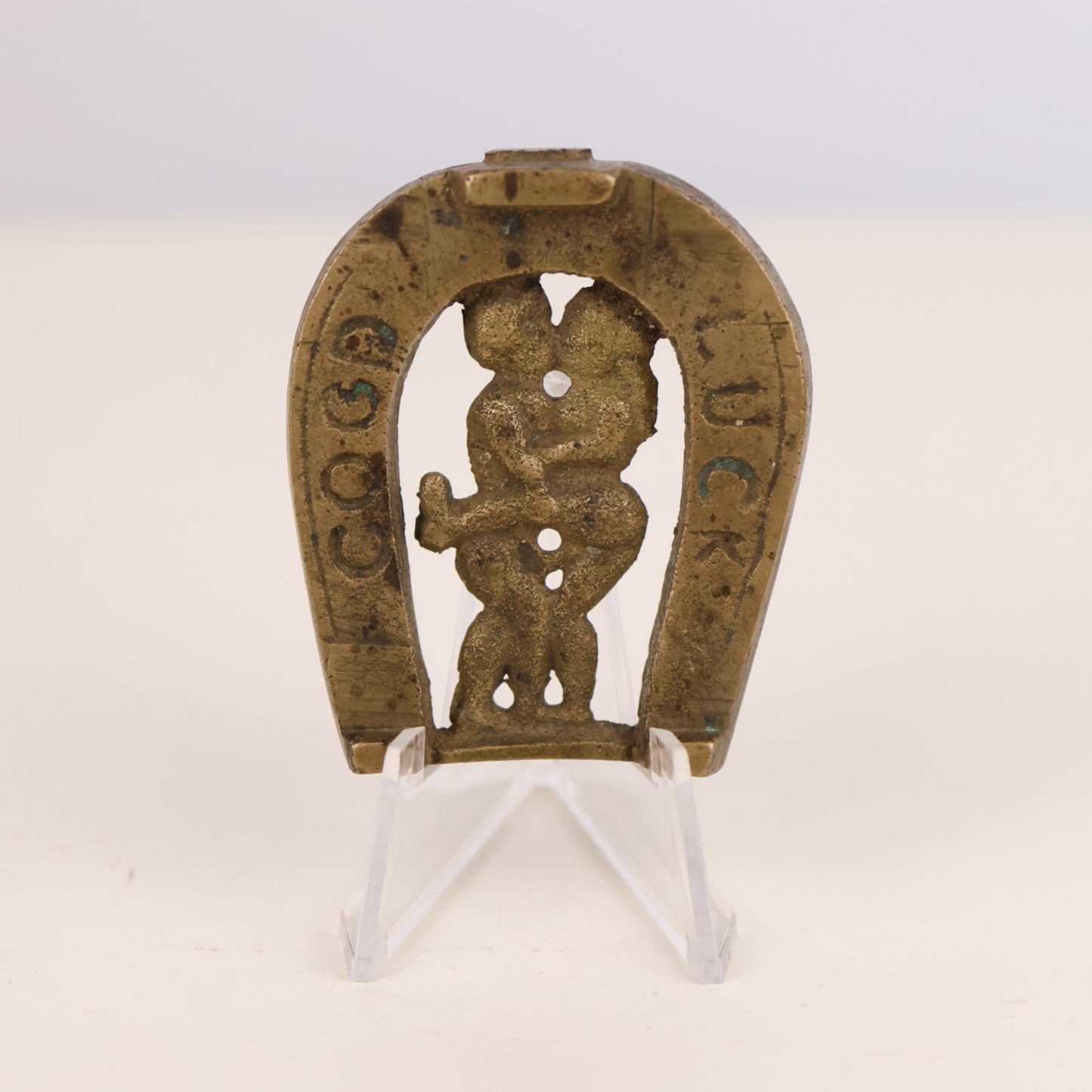 Decorative horseshoe with a naughty figure and text on a white background