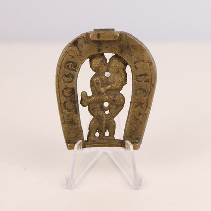 Decorative horseshoe with a naughty figure and text on a white background