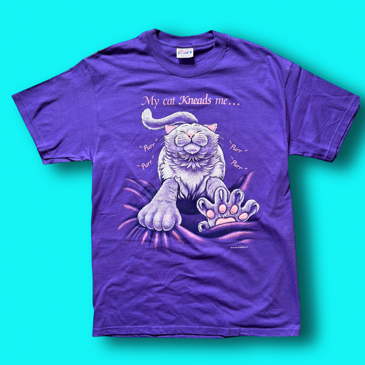 A purple t-shirt with a graphic print of a cat and the text 'My cat kneads me." Vintage Hep Cat Tee.