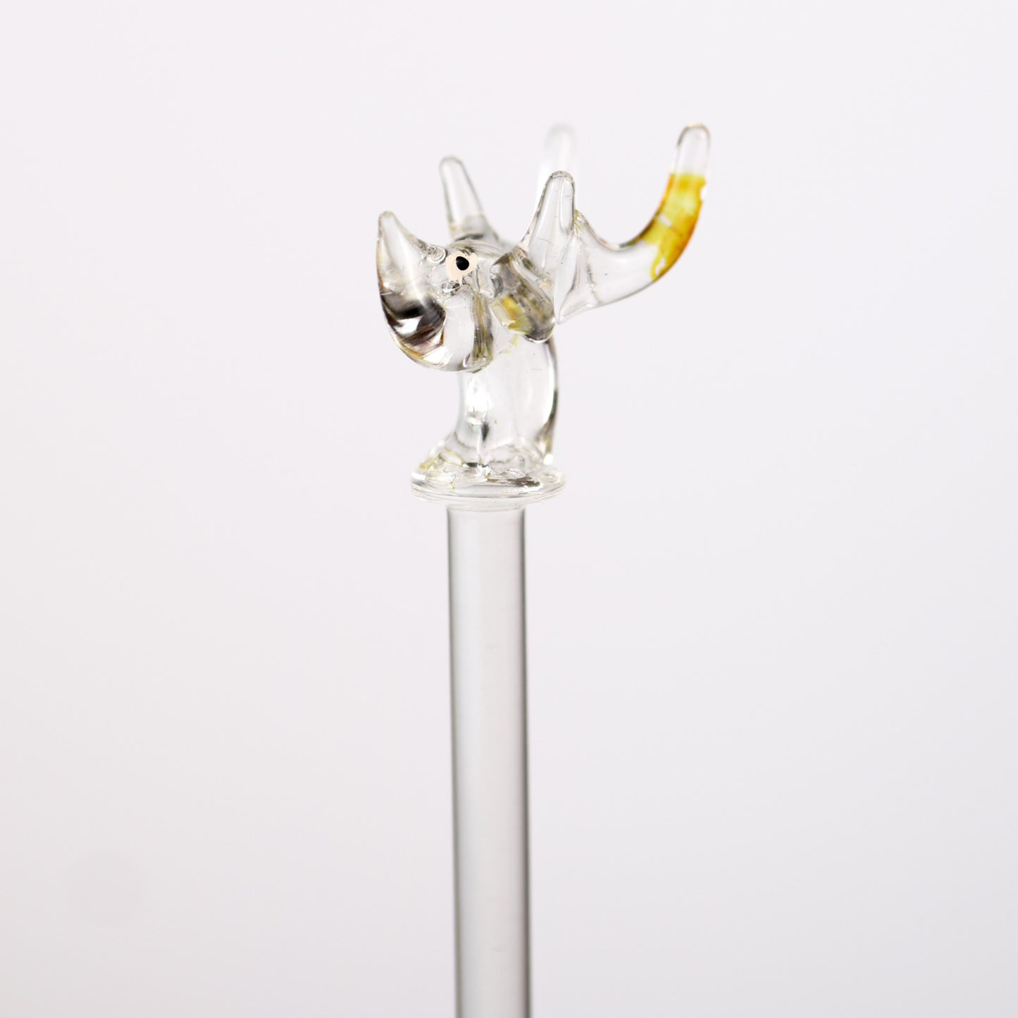 Glass swizzle stick with a decorative deertopper on a white background