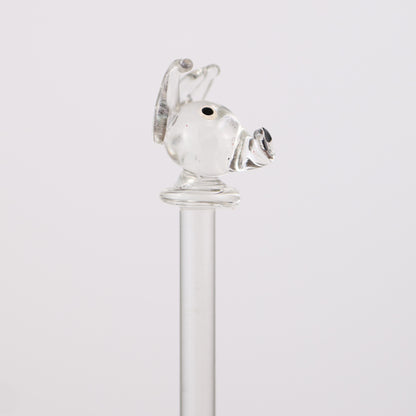 Clear glass swizzle stick with a dog design on a white background