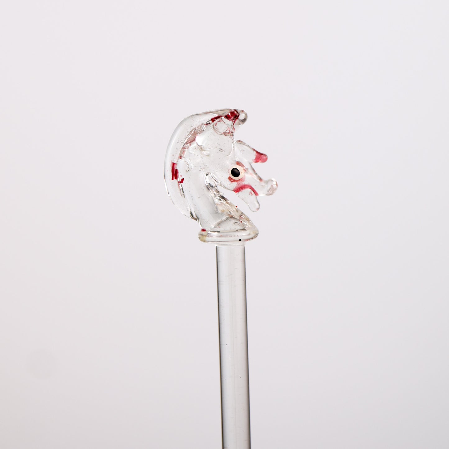Glassswizzle stick with a horse head design on a white background