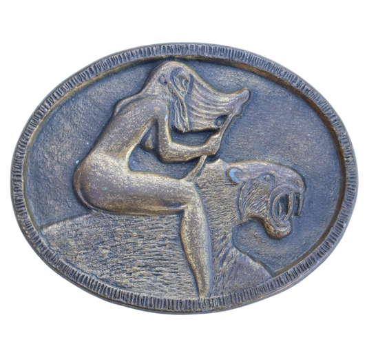 vintage belt buckle of a woman riding a sabertooth tiger